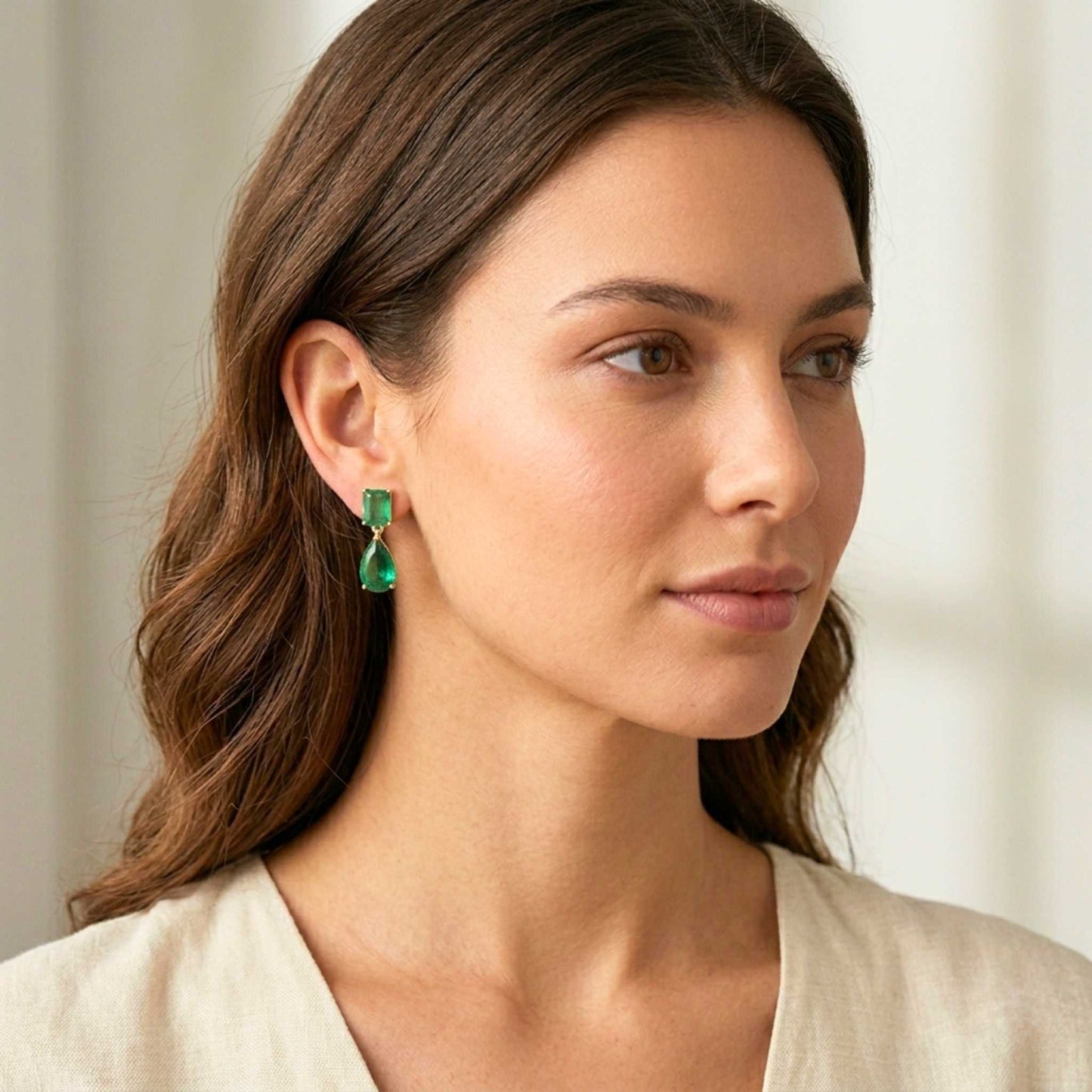 Woman wearing green earrings with a neutral background. Digitally rendered model for scale.