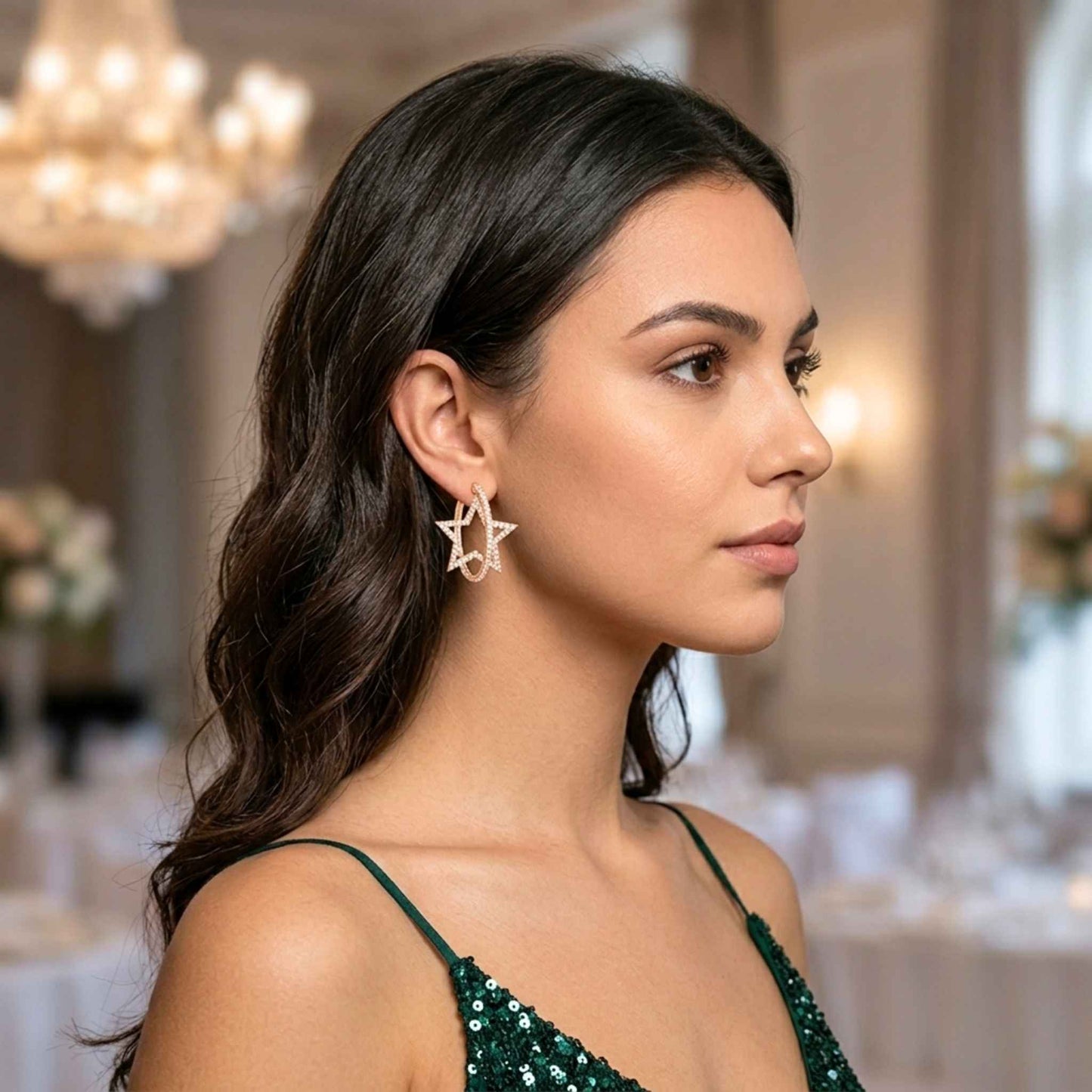 Side view of a woman wearing gold star-shaped hoop earrings from the Jewellery 4 Elegance collection set in an elegant indoor setting. Digitally rendered model for scale