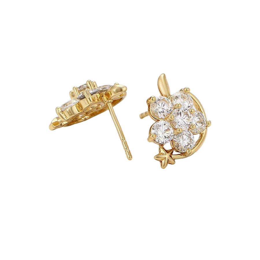 Gold earrings with clear gemstones on a light background