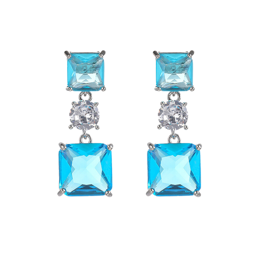 Pair of earrings with two blue square zirconia stones earrings connected by a central clear stones on a white background