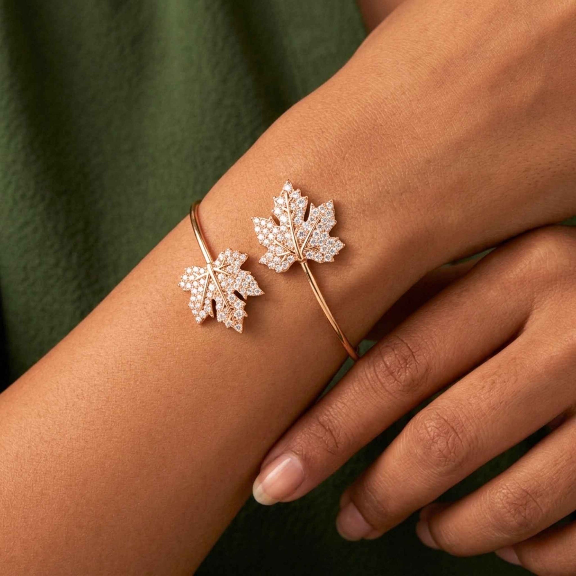 Leaf-shaped gold bangle bracelet on a person's wrist against a green background.  Digitally rendered model for scale