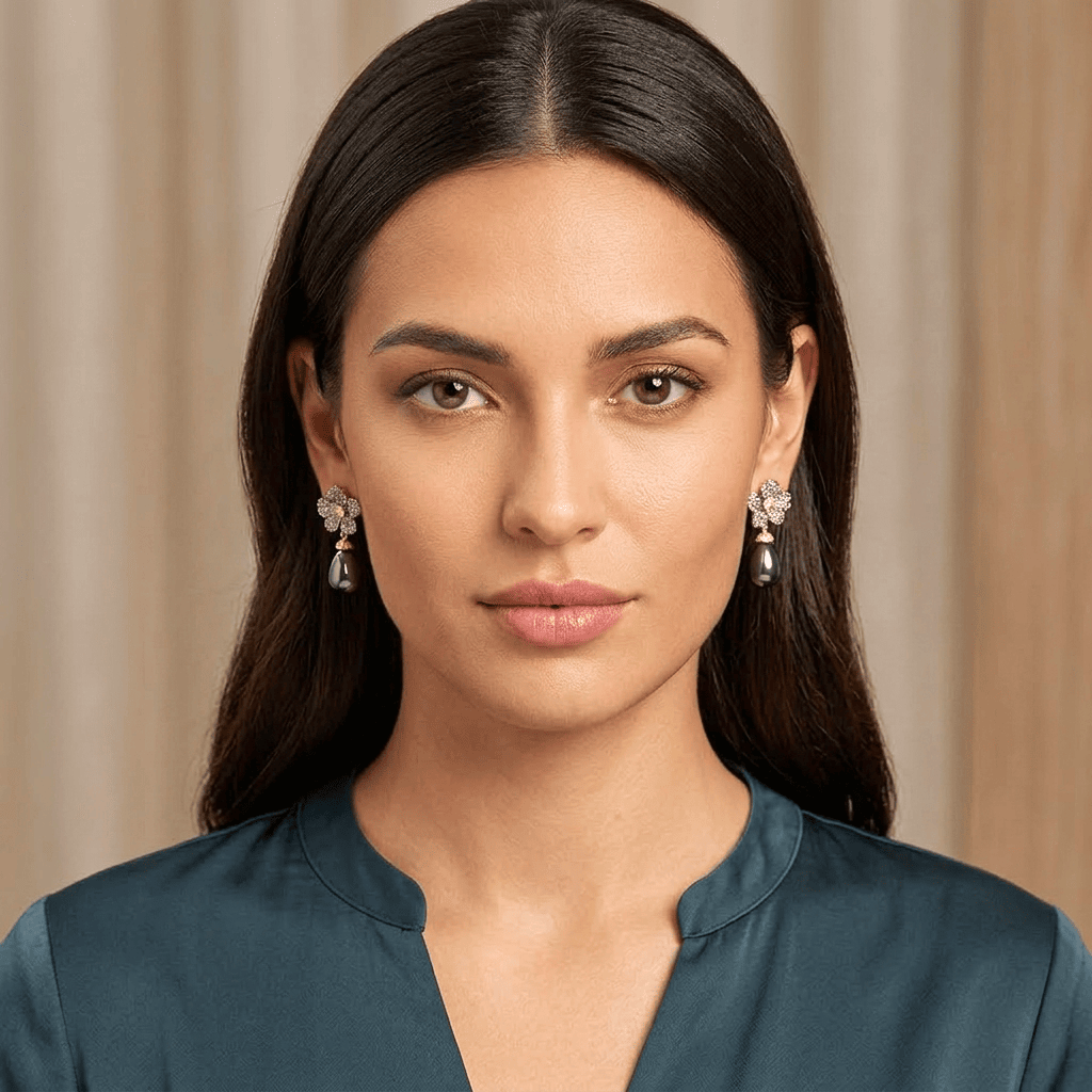Woman wearing black pearl earrings with a neutral background