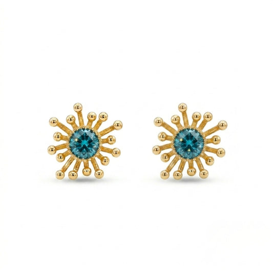 Gold sunburst earrings with blue gemstones on a white background