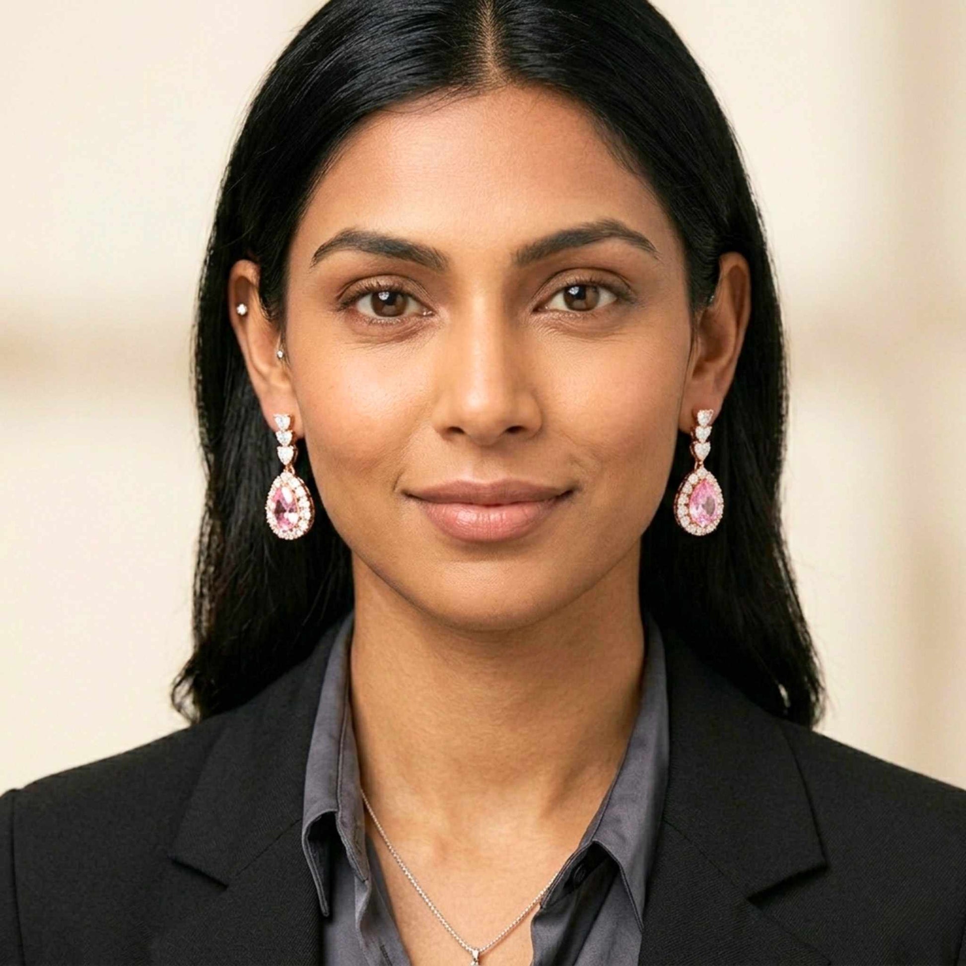 Woman wearing pink earrings with cz gemstone against a neutral background.  Digitally rendered model for scale   