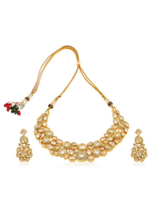 Gold necklace and earrings set in an Indian style with mint hue finish colour against a white background.