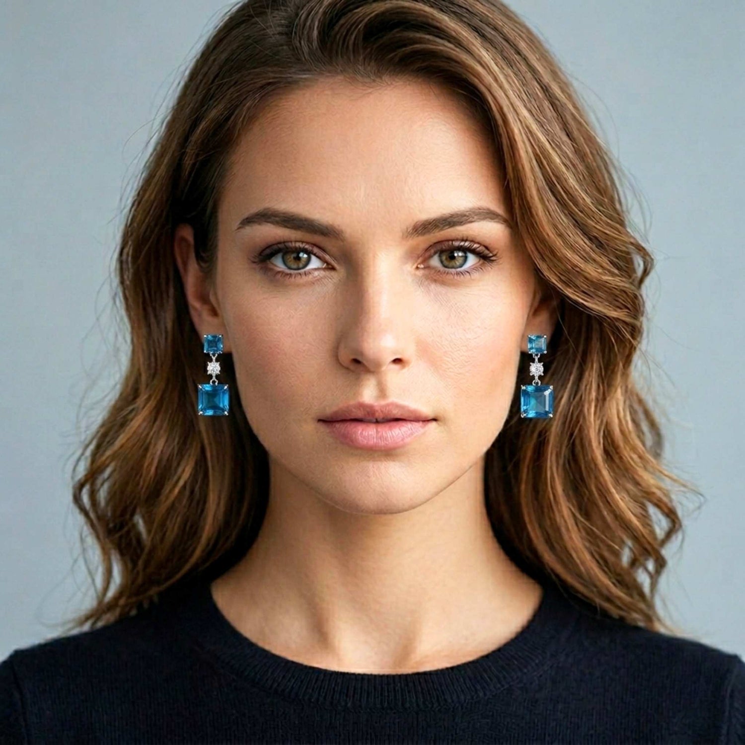 Attractive woman wearing blue earrings against a plain background.  Digitally rendered model for scale.