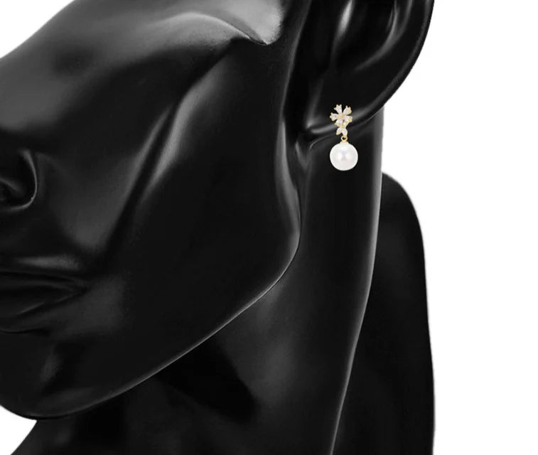 Pearl drop earring with sparkling gemstones shown on a model.  Gold pearl earrings for women.