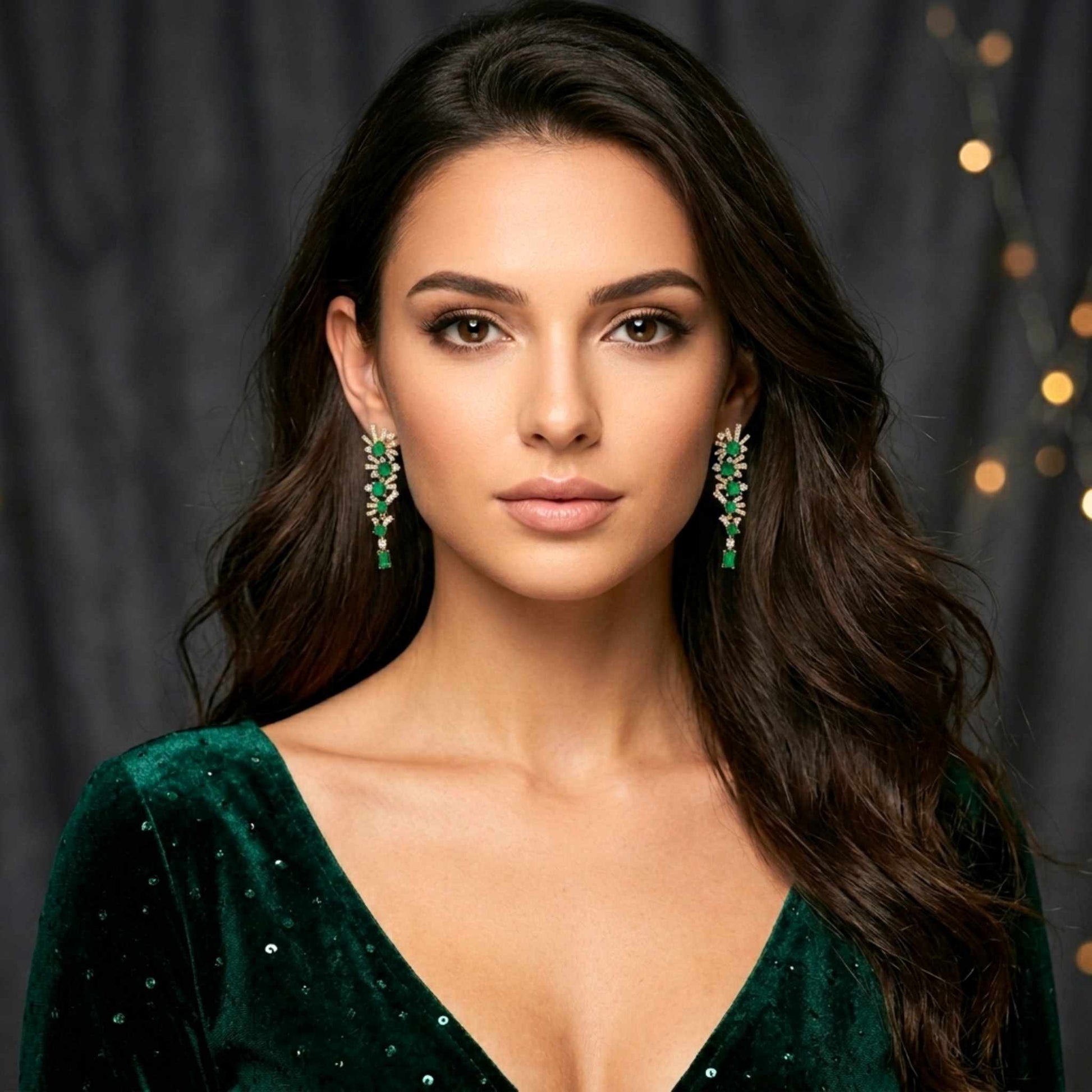 Woman wearing green gold earrings and a green dress against a dark background with lights.  Digitally rendered person wearing authentic jewellery.