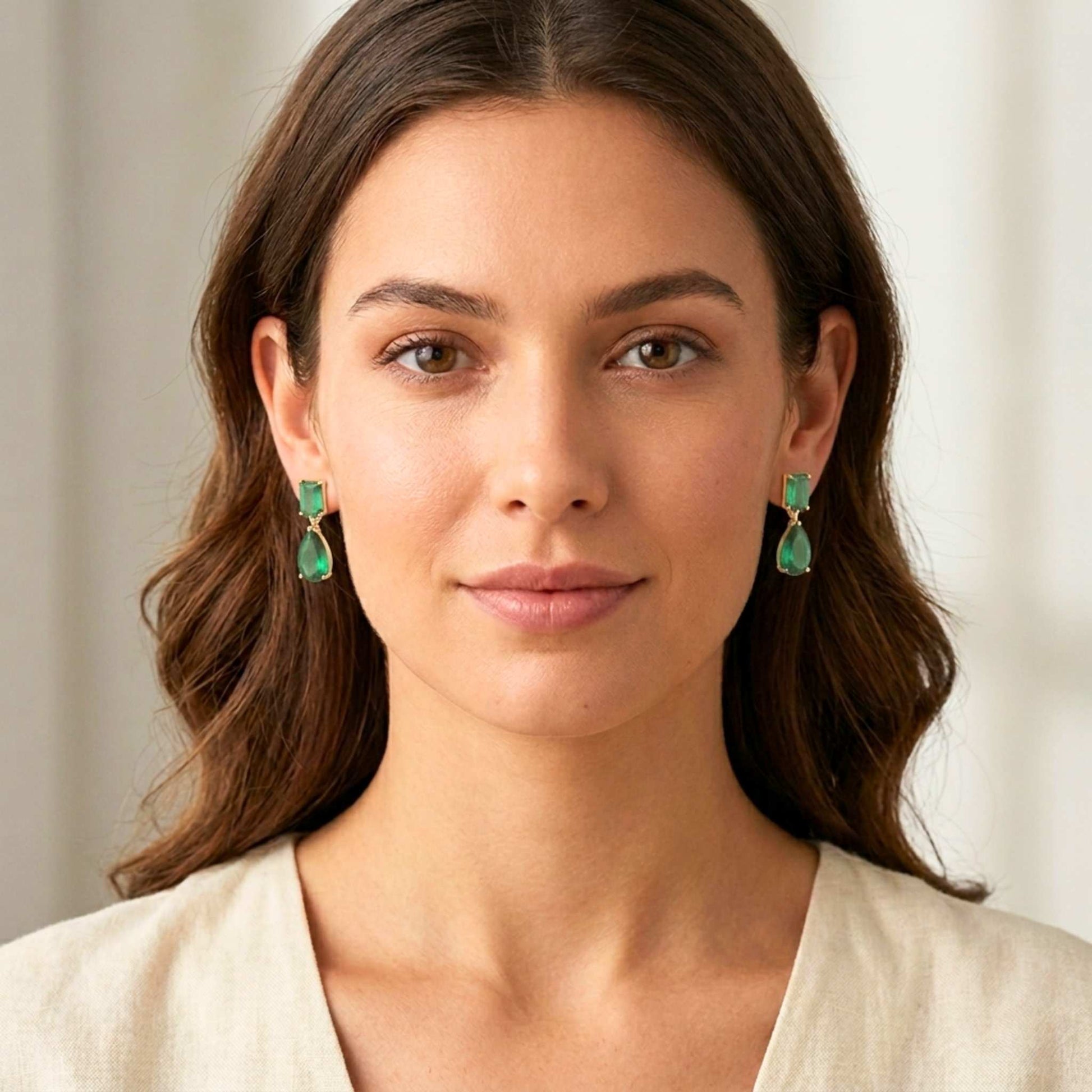 Woman wearing green earrings with a neutral background.  Digitally rendered model for scale.