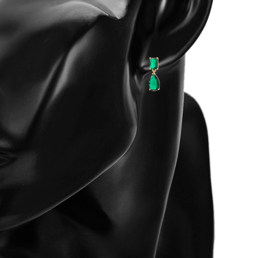 Green emerald earring on a model against a white background