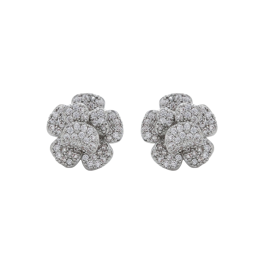 Pair of white gold flower-shaped earrings on a white background