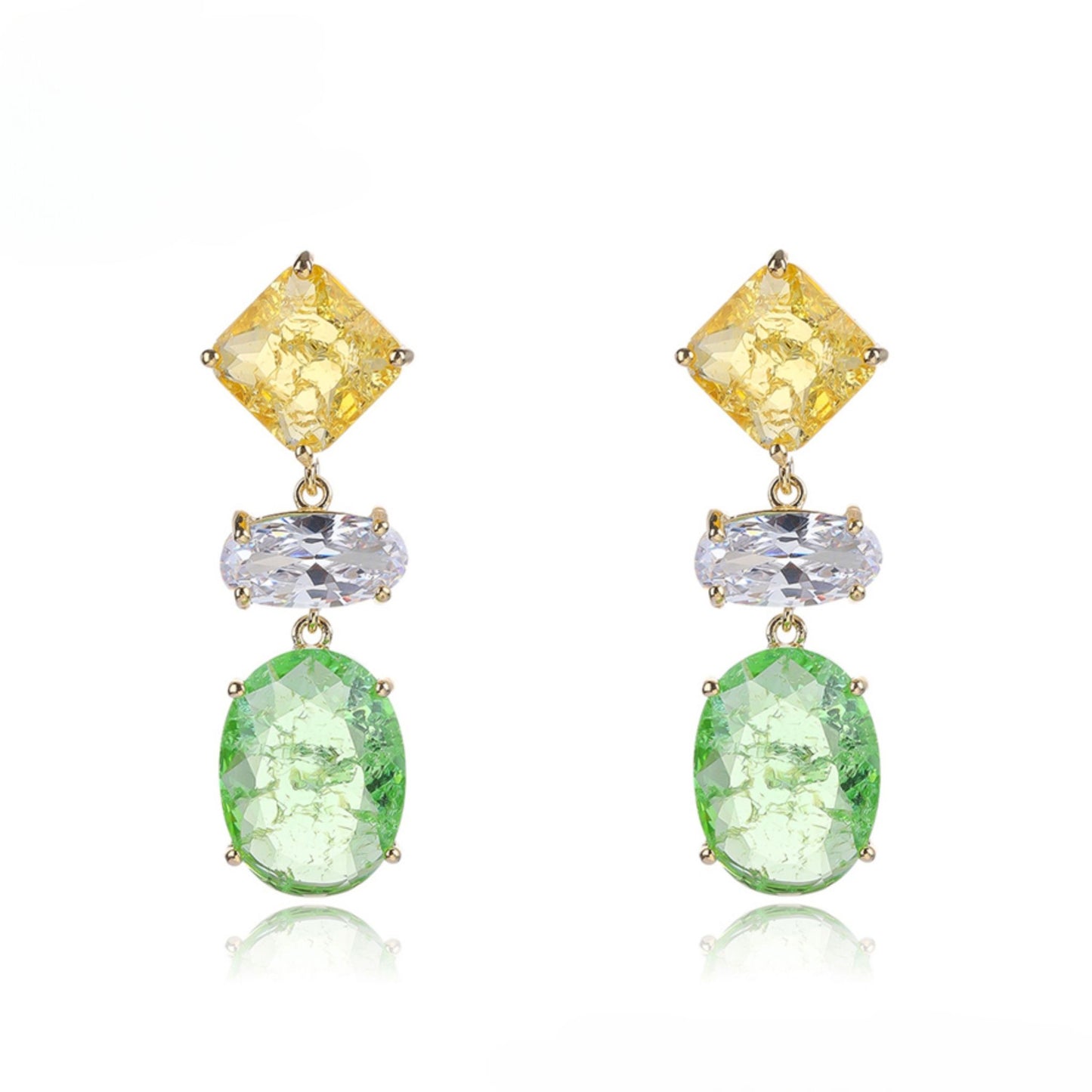 Pair of earrings with yellow, clear, and green gemstones on a white background