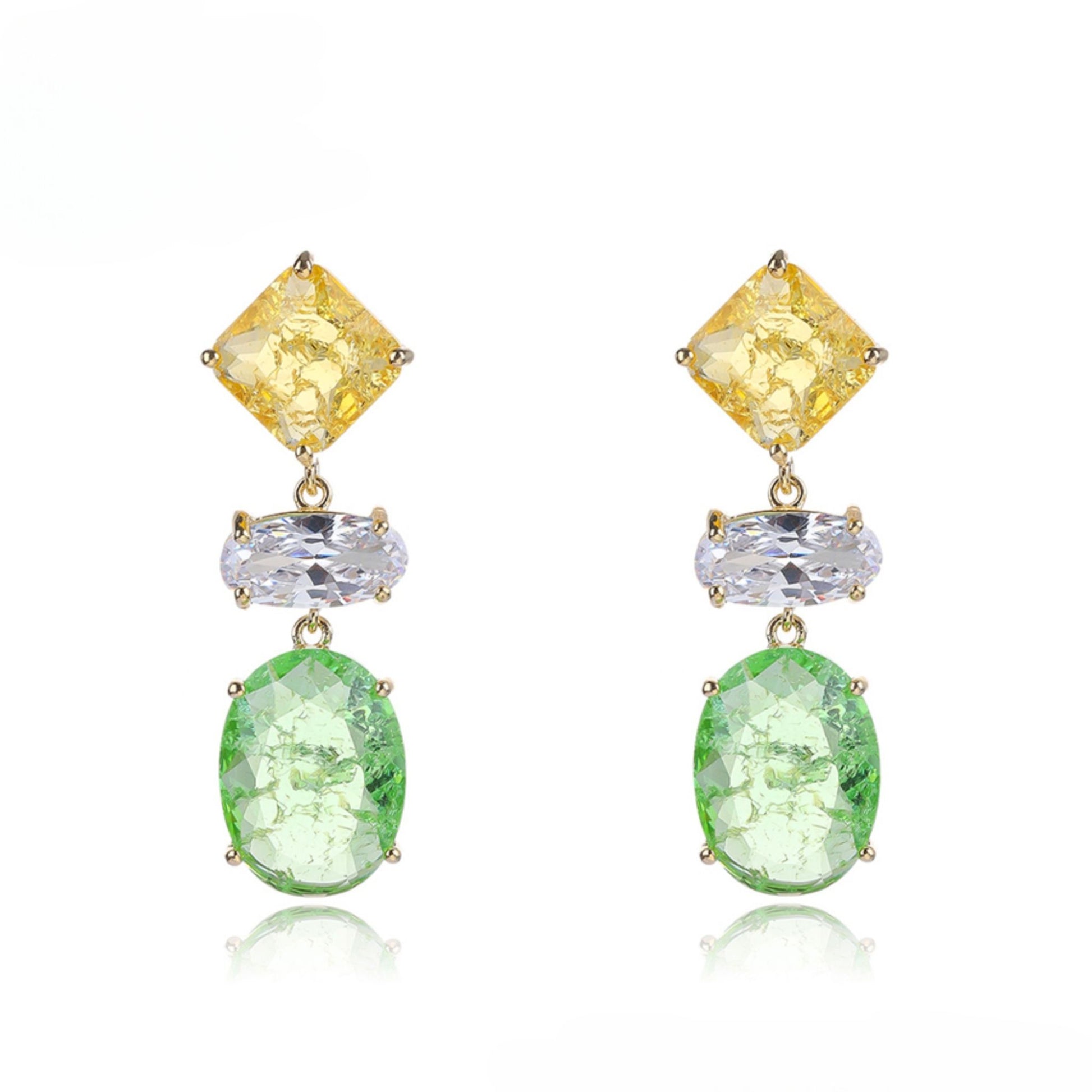 Pair of earrings with yellow, clear, and green gemstones on a white background