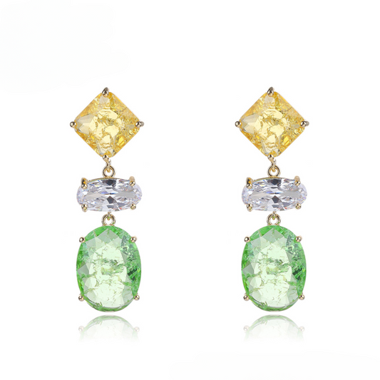 Pair of earrings with yellow, clear, and green gemstones on a white background