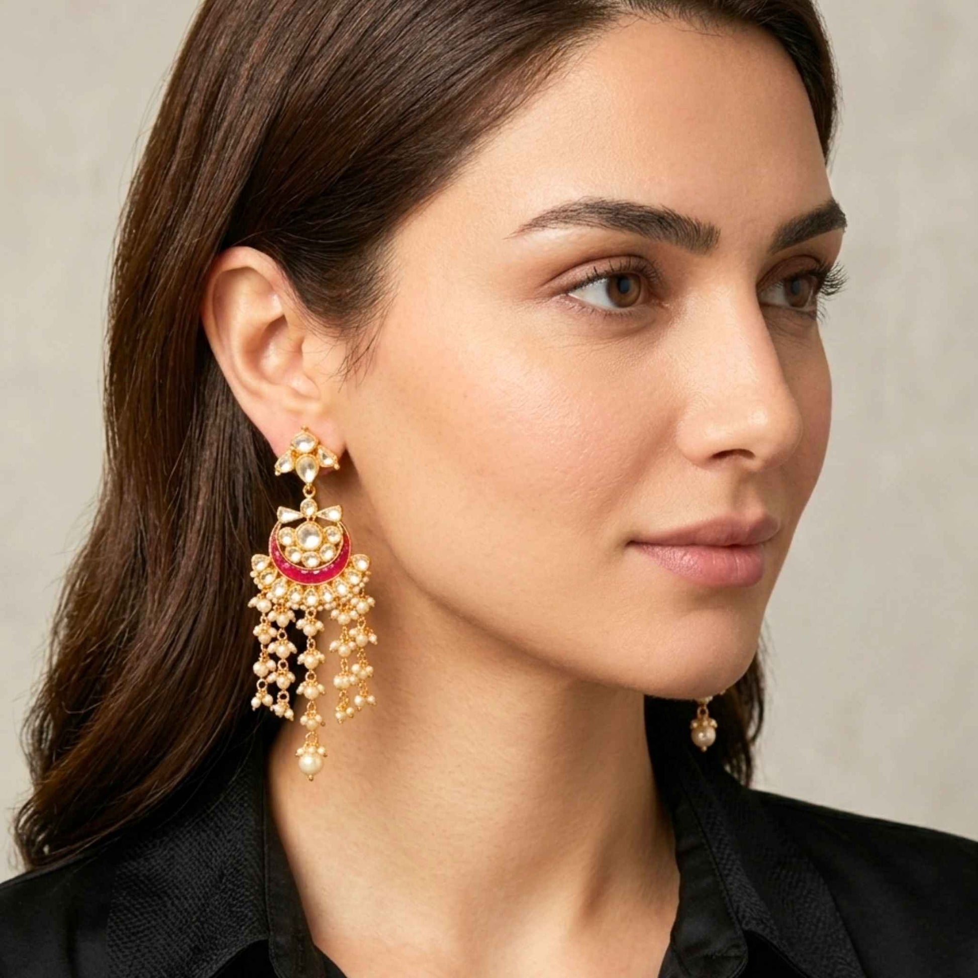 Woman wearing Indian gold dangler earrings with a neutral background.  Digitally rendered model for scale