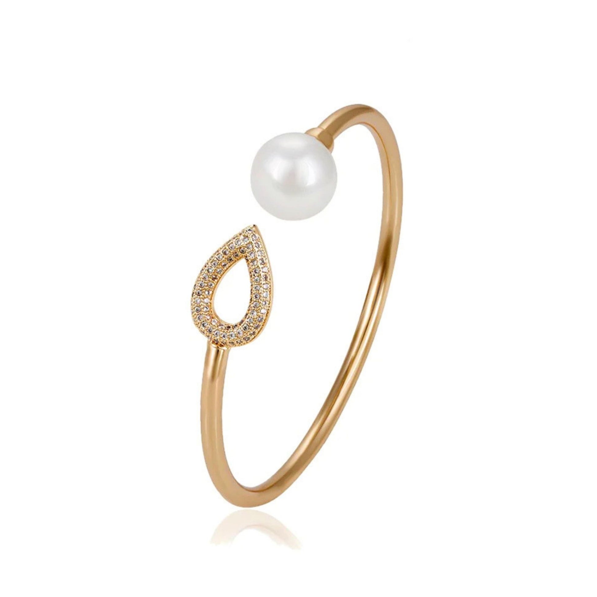 Gold bracelet with a pearl and teardrop-shaped charm accentuated with cubic zirconia on a white background