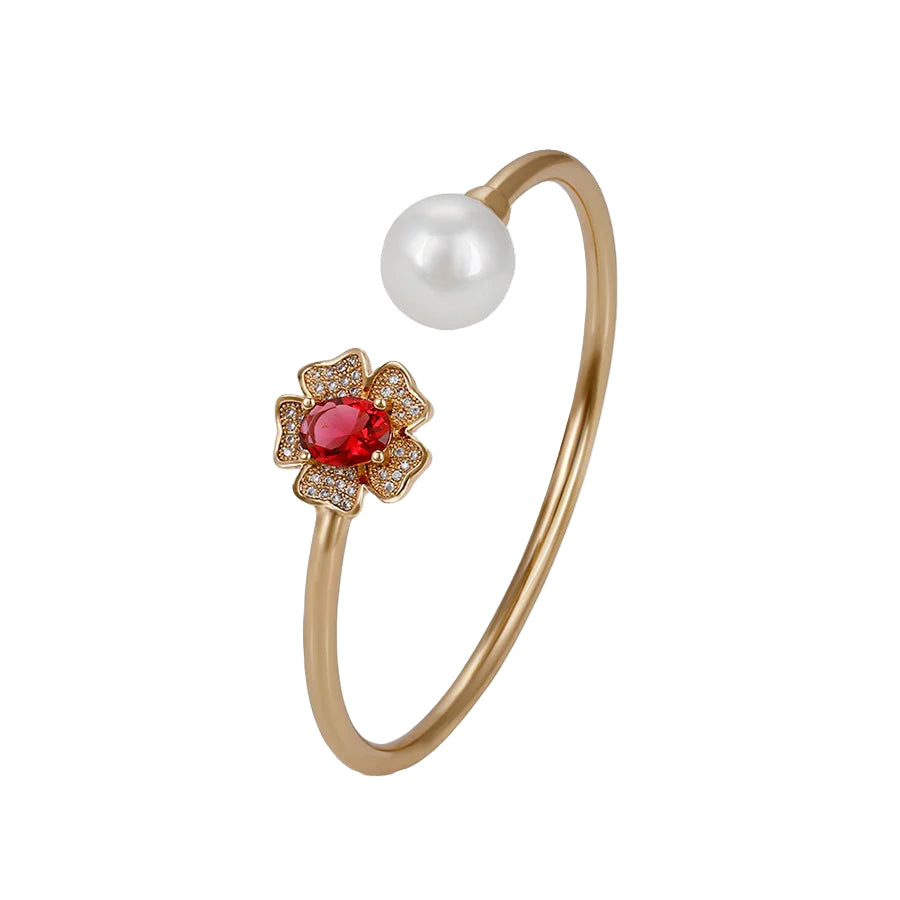 An 18k gold plated bracelet featuring a pearl and a rose colored zirconia stone, with a floral design.