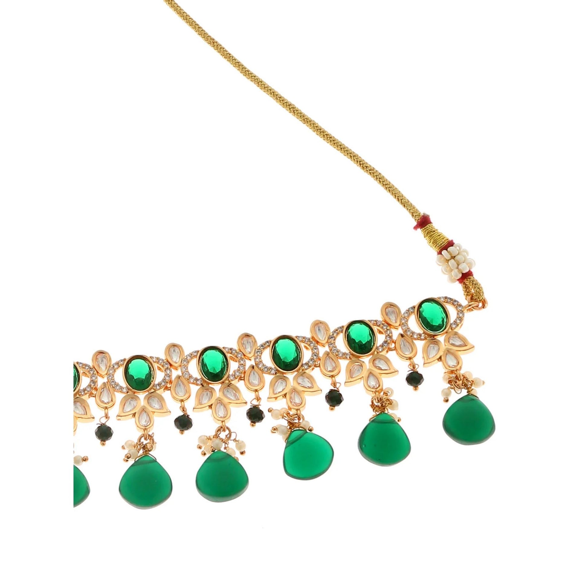 Gold necklace with green gemstones on a white background