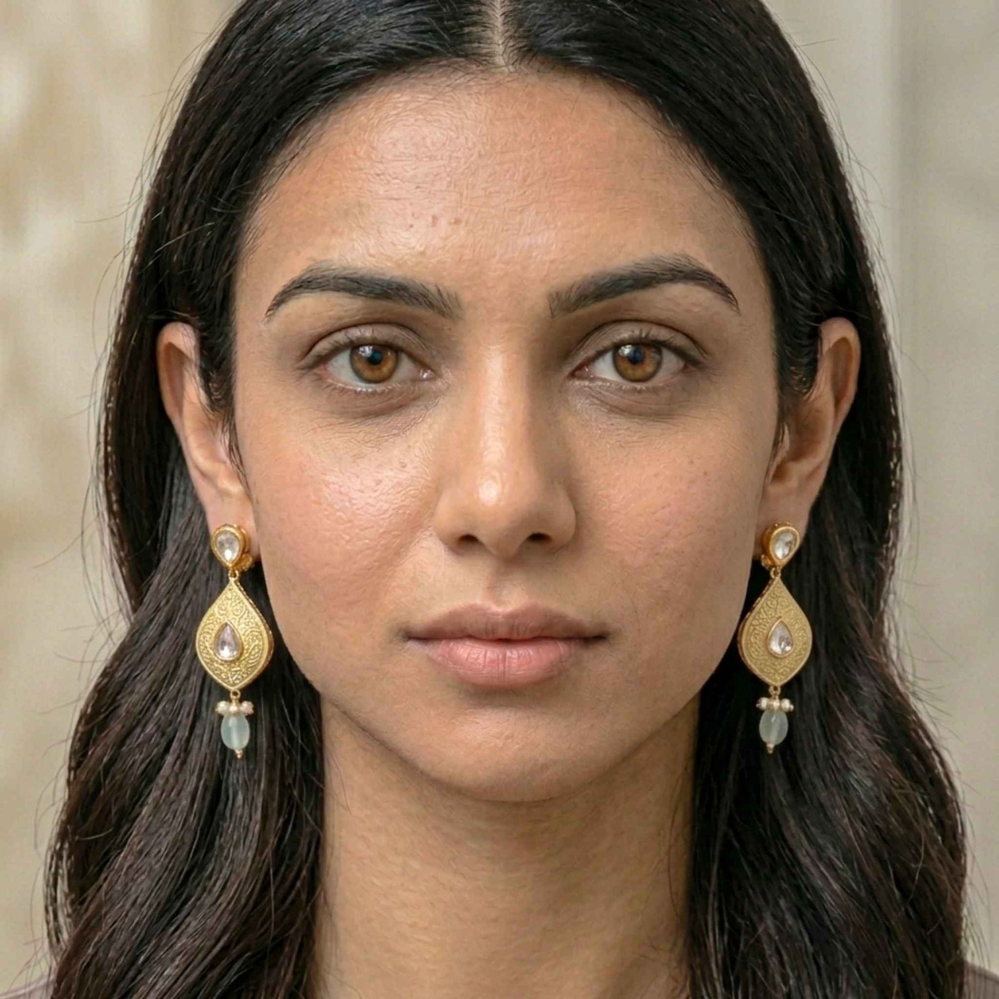 Woman wearing gold earrings with a neutral background.  Digitally rendered model for scale.