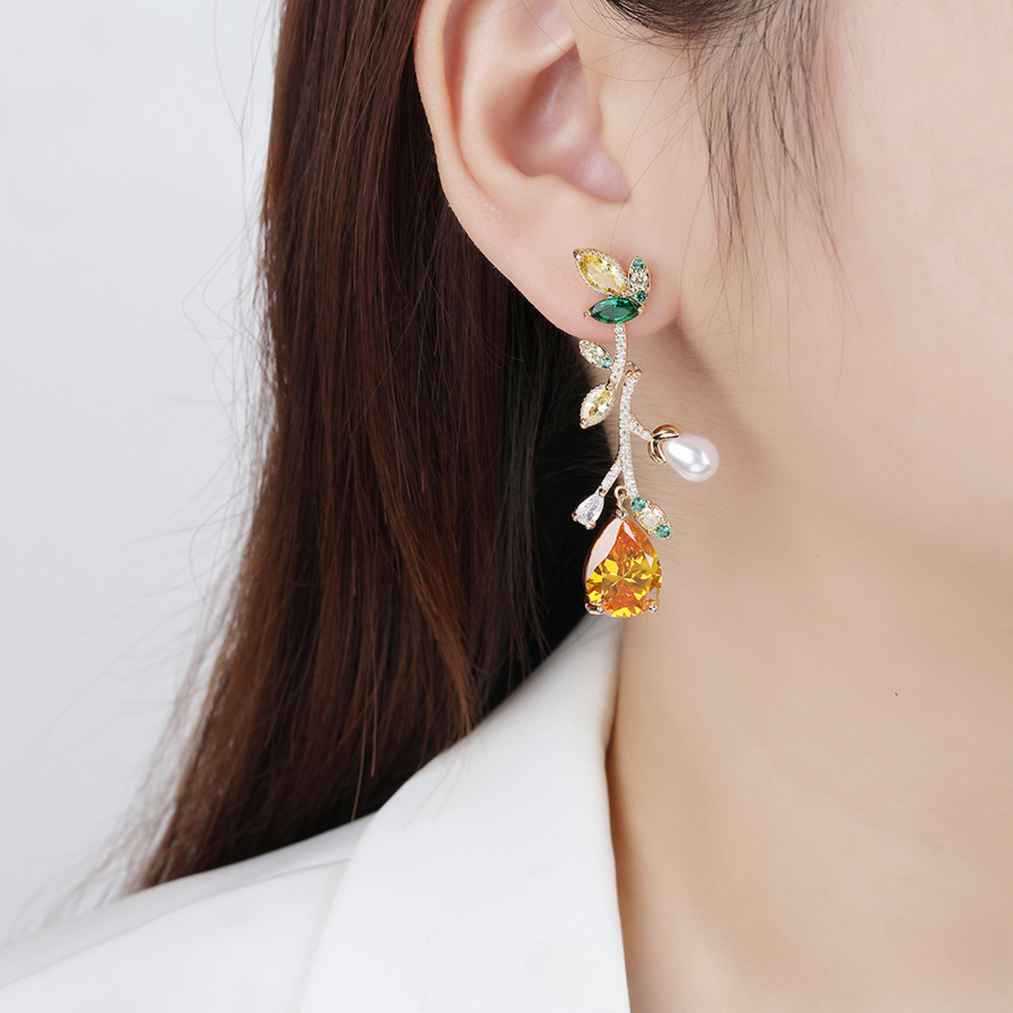 Close-up of a person wearing colorful earrings with a white background