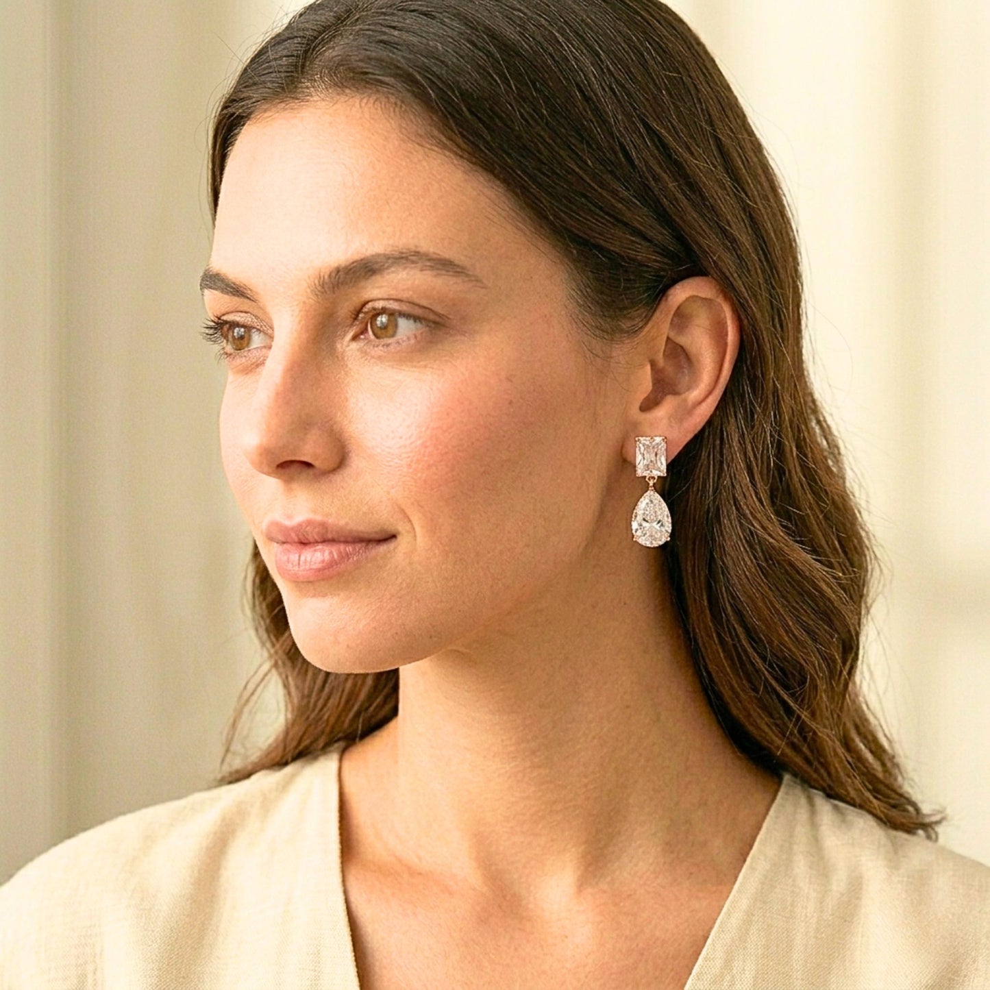 Woman wearing diamond earrings with a neutral background.  Digitally rendered person wearing authentic jewellery.