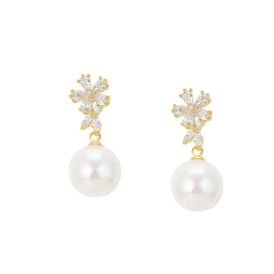 pair of stud white pearl earrings with cz gemstones against a white background