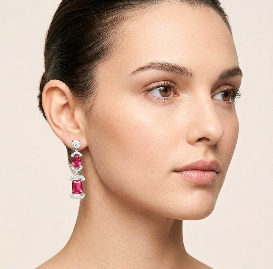 Close-up of a woman wearing a pair of red earrings with a light background