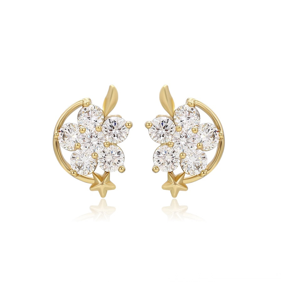 Gold earrings with star encircling a floral design of clear stones on a white background