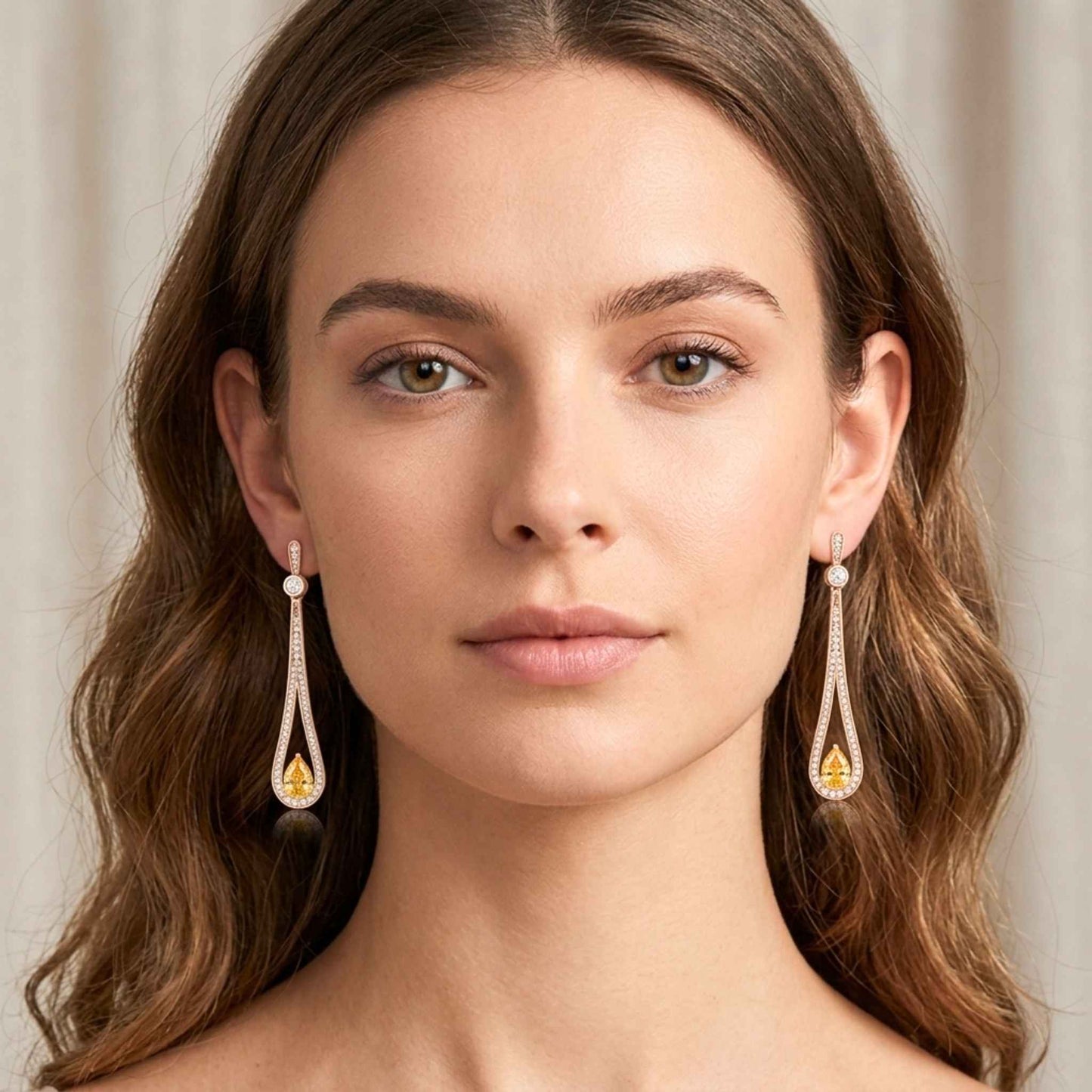 Women wearing a pair of tear drop earrings with clear and yellow gemstones.  Digitally rendered model for scale