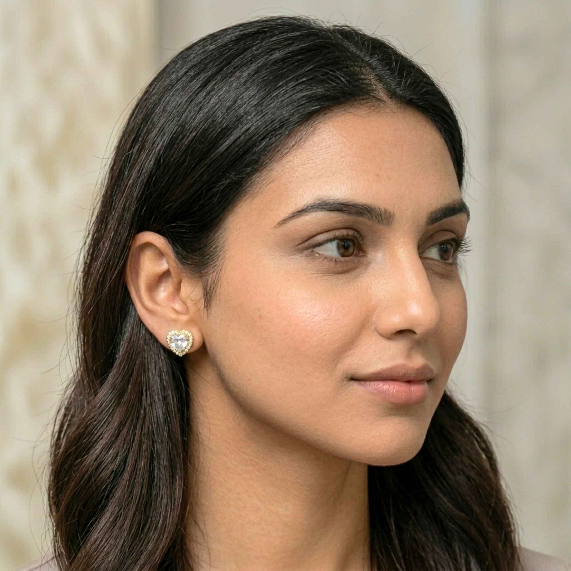 Close-up of a woman wearing a heart-shaped earring with a neutral background.  Digitally rendered model for scale