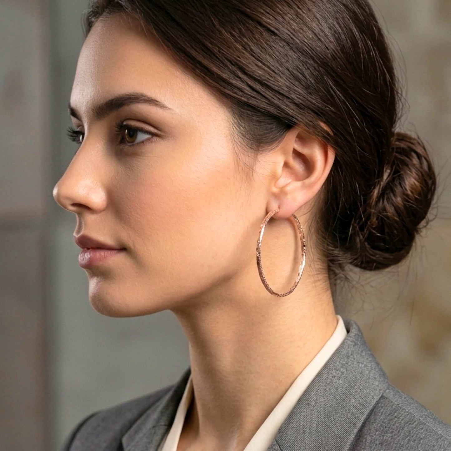 Woman wearing hoop earrings with a blurred background.  Digitally rendered model for scale.