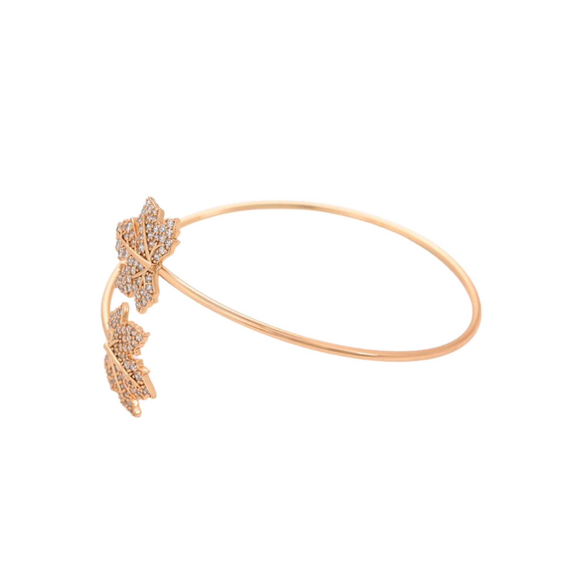 Gold bracelet with leaf-like designs on a white background