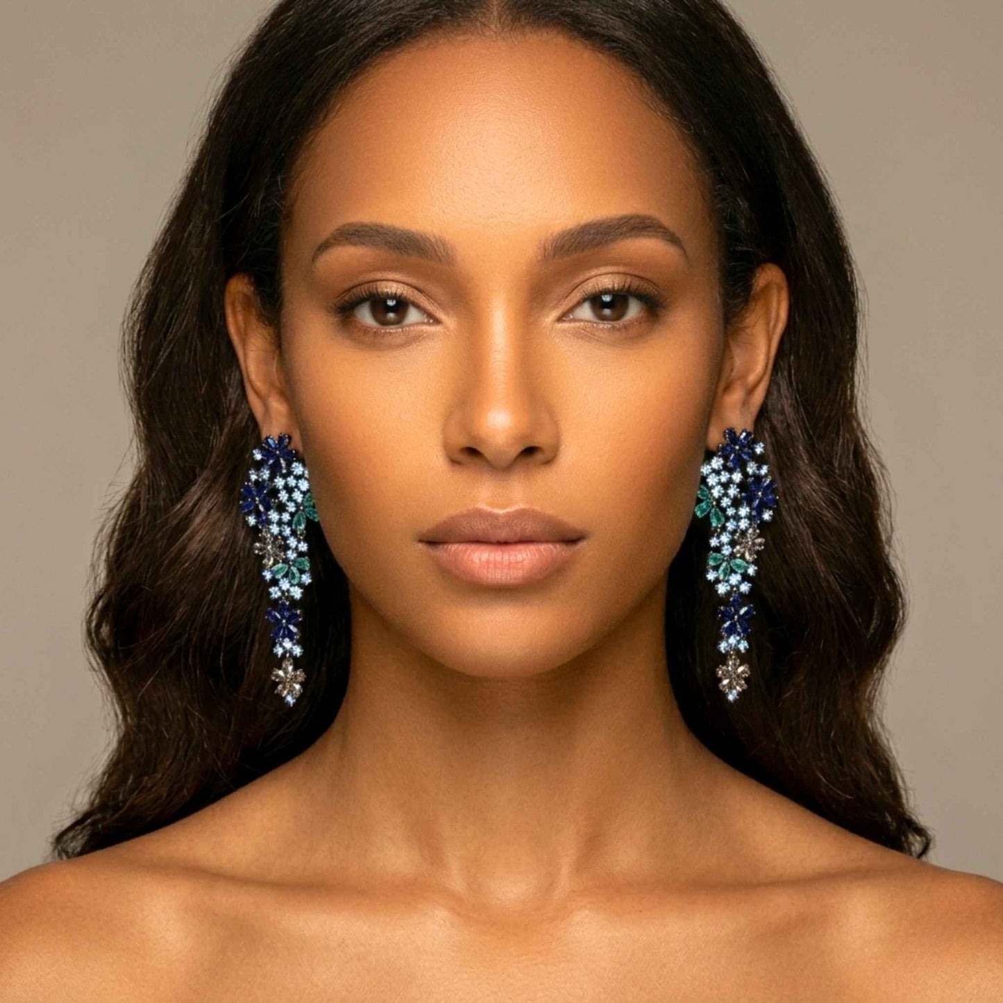 Women wearing multi-coloured petal design earrings against a plain background.  Digitally rendered model for scale.