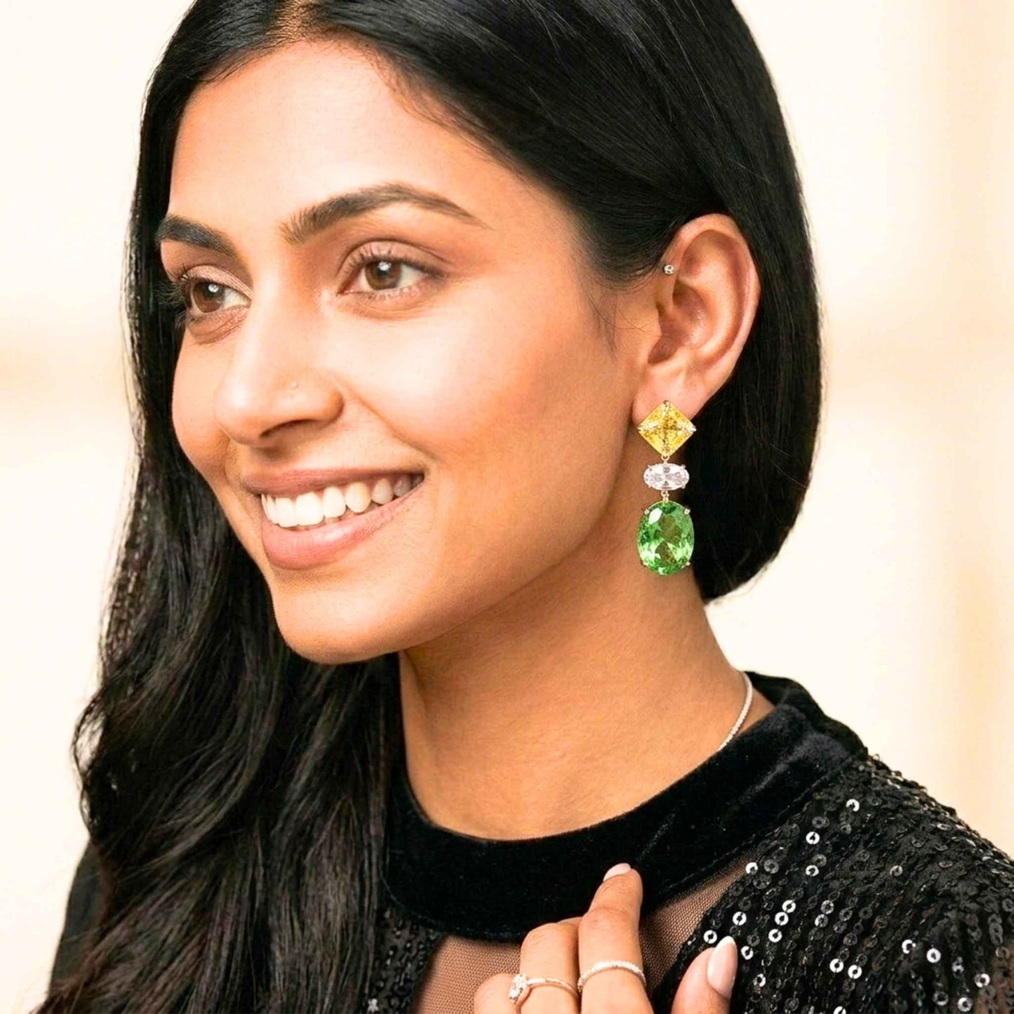 Woman wearing green and yellow earrings with a neutral background.  Digitally rendered model for scale.