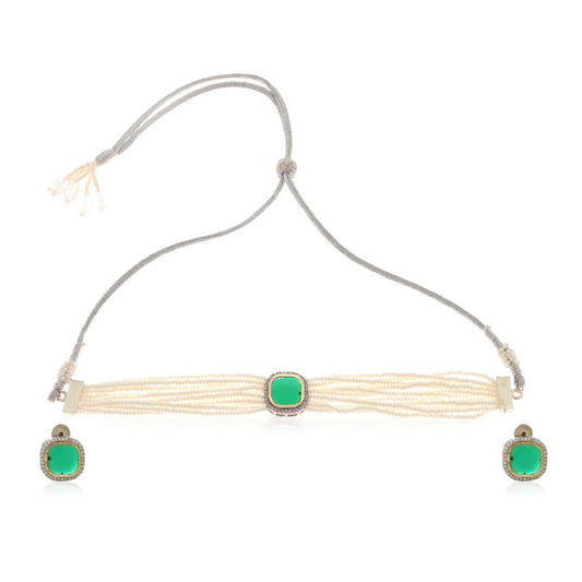 Necklace with pearls and green gemstone and matching earrings on a white background