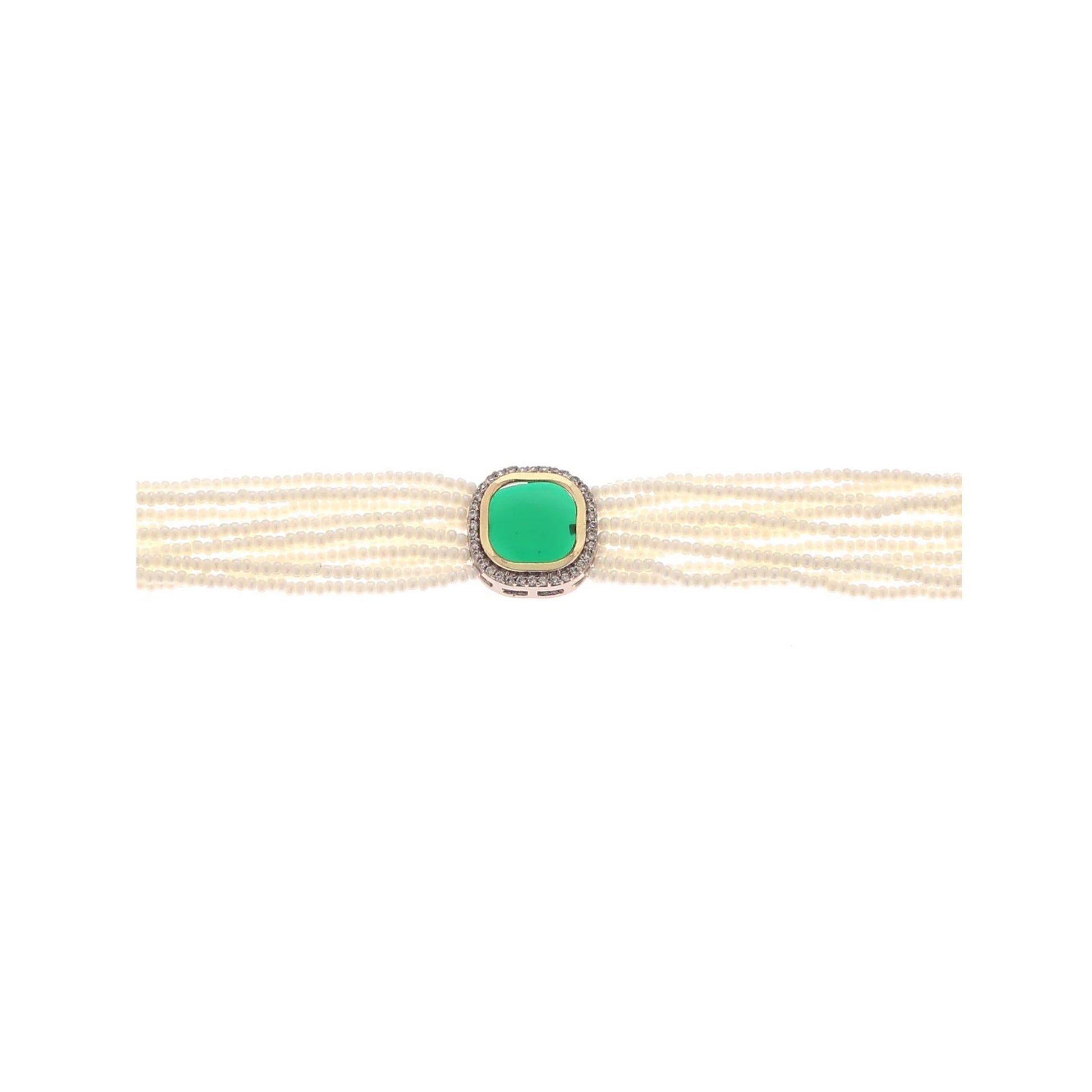 Bracelet with multiple pearl strands and a green stone on a white background