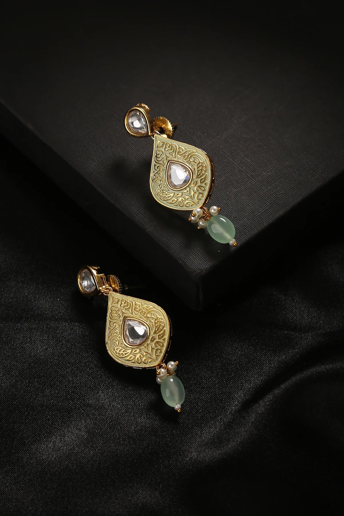 Persian style earrings in gold against a black background