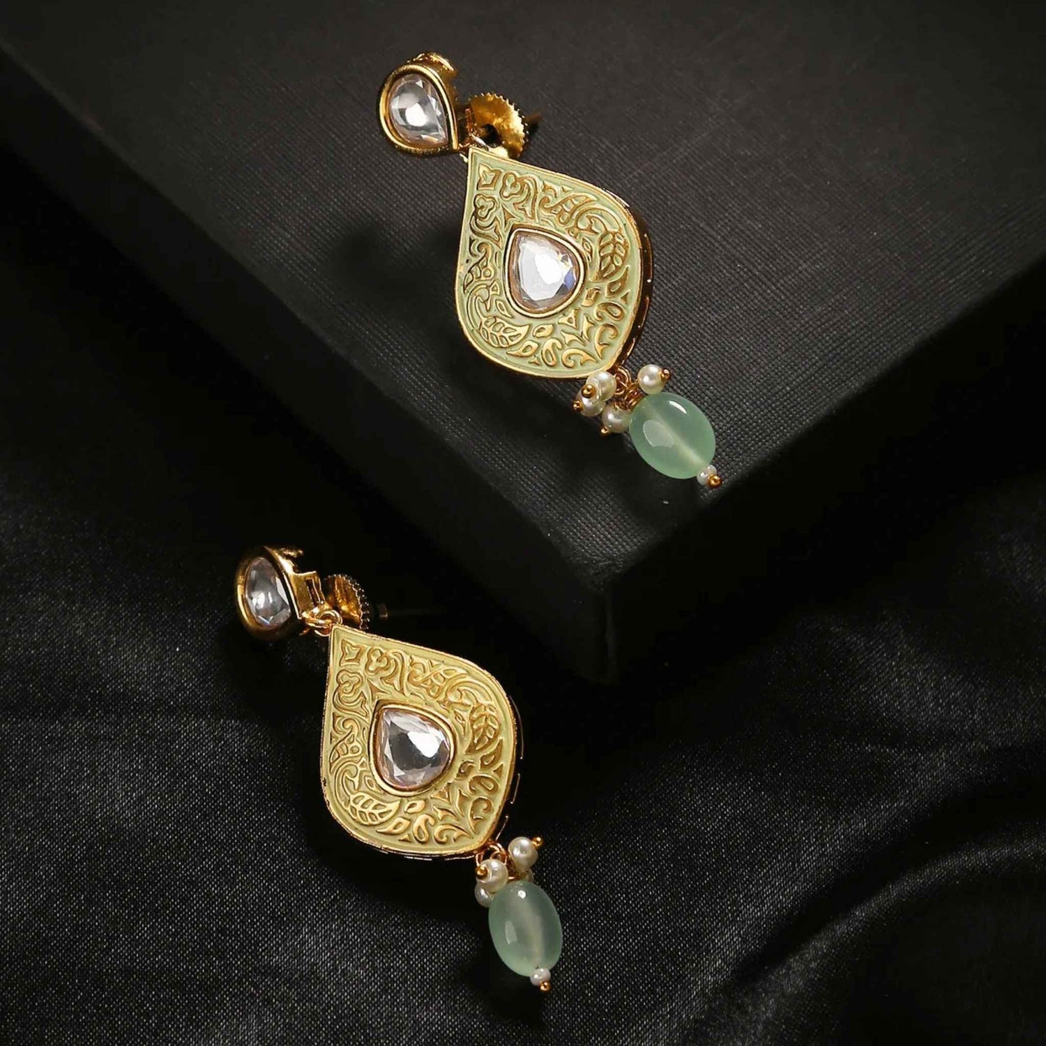 Persian style earrings in gold against a black background