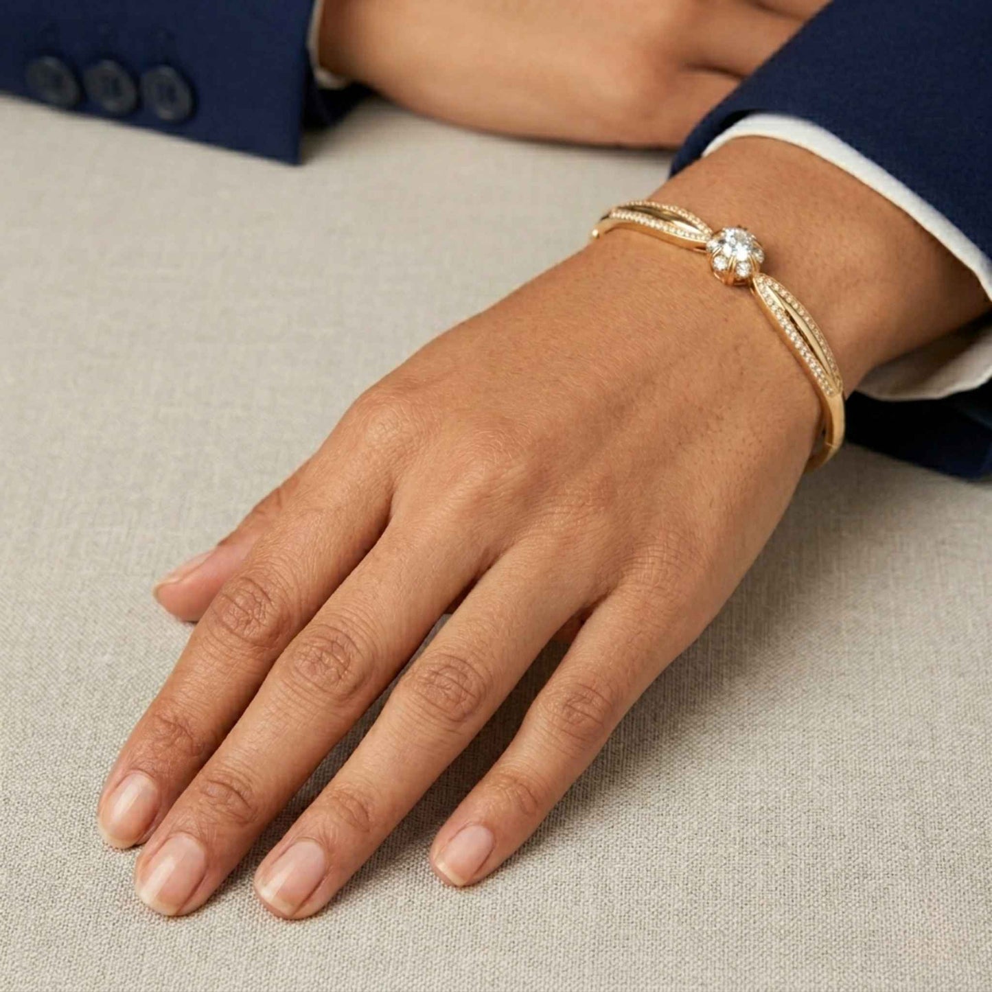 Gold bangle bracelet from the Jewellery 4 Elegance collection on a women's wrist against a neutral background.  Digitally rendered model for scale