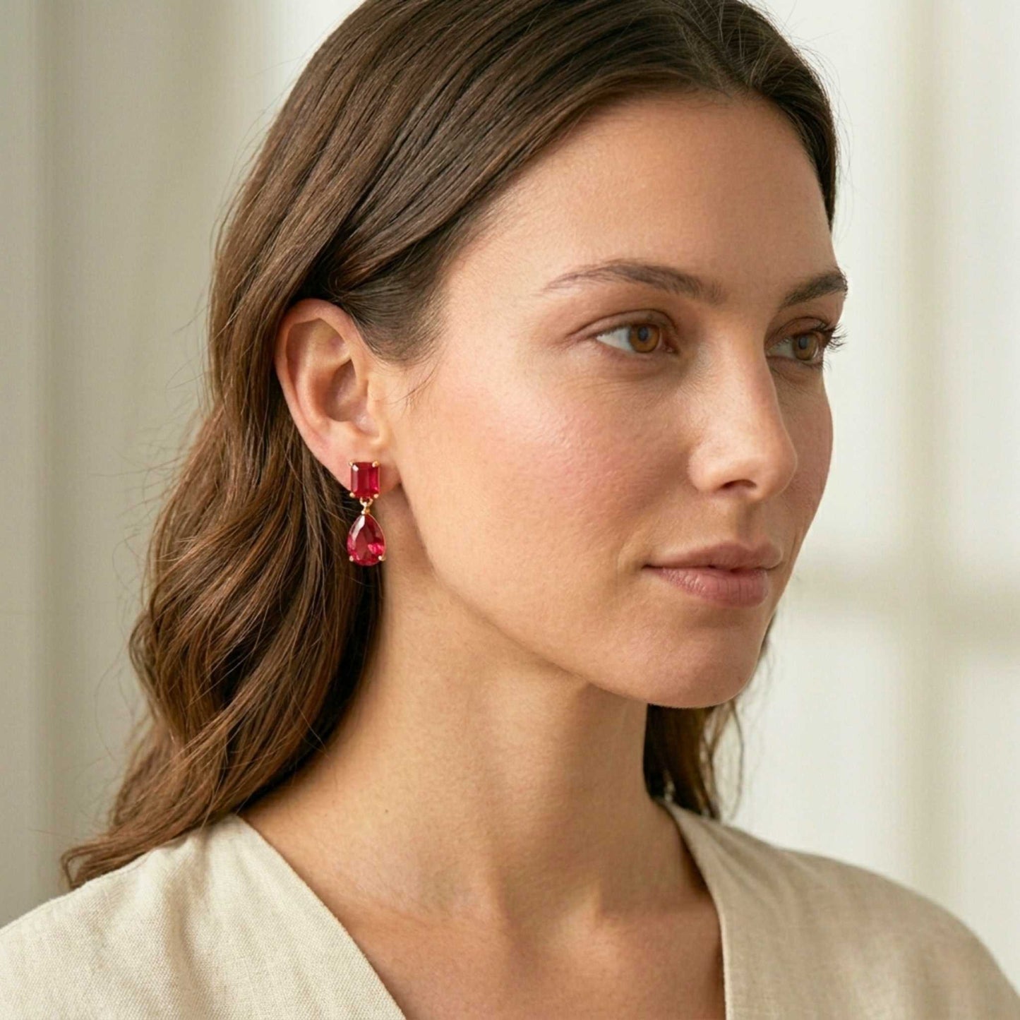 Woman wearing red earrings with a neutral background.  Digitally rendered model for scale