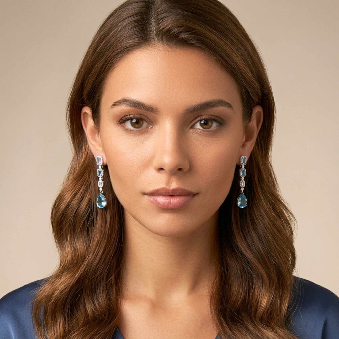 Woman wearing blue earrings against a neutral background.  Digitally rendered model for scale.