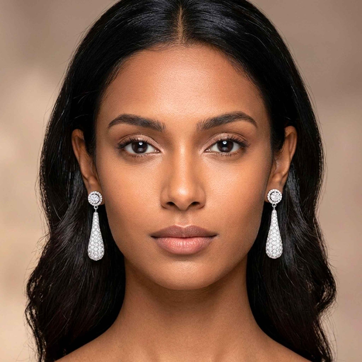 Woman wearing elegant teardrop earrings against a neutral background.  Digitally rendered model for scale