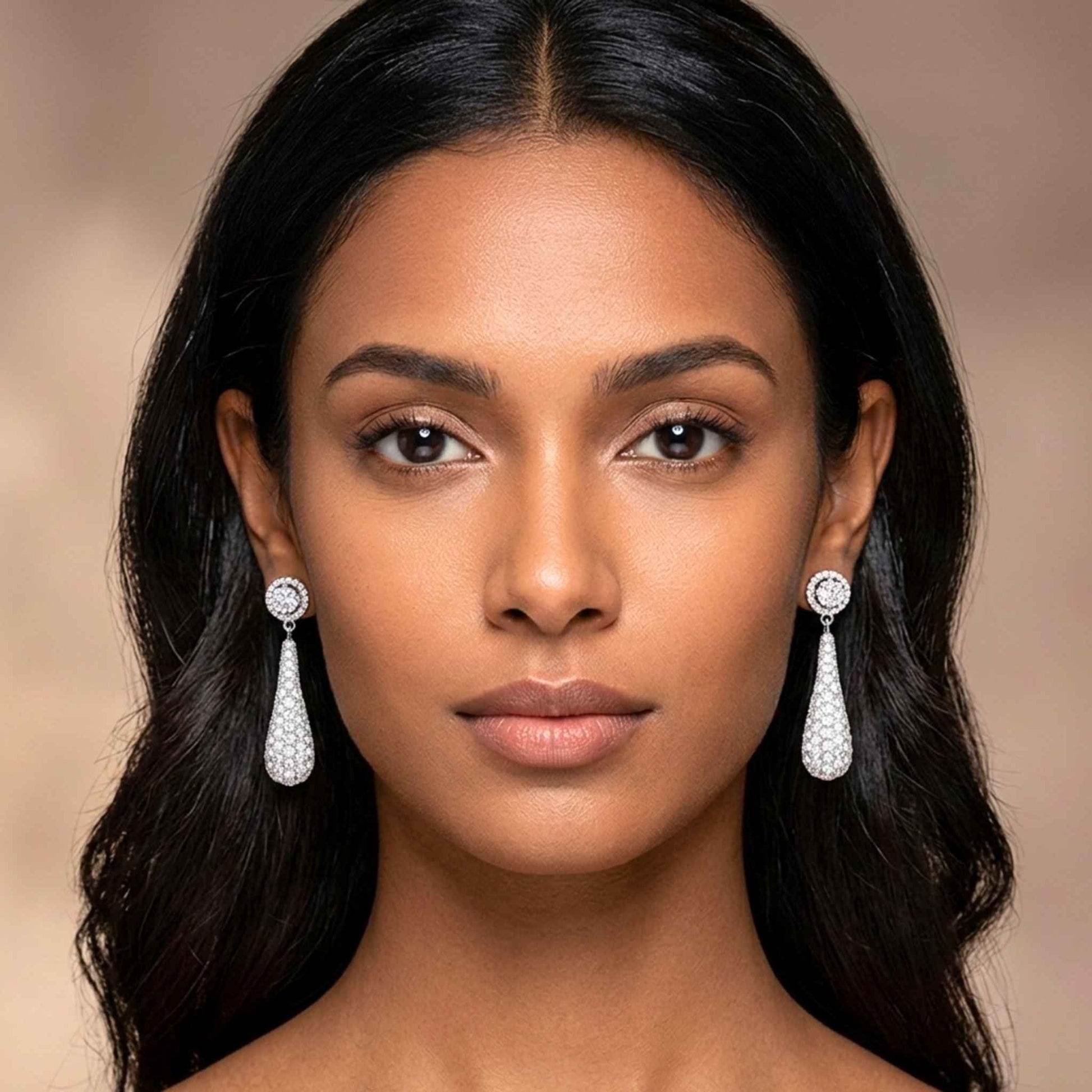 Woman wearing elegant teardrop earrings against a neutral background.  Digitally rendered model for scale