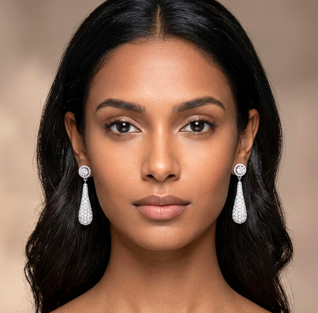 Woman wearing elegant teardrop earrings against a neutral background