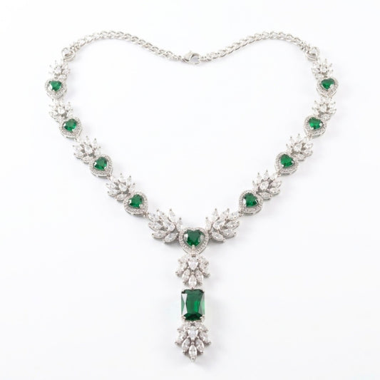 Elegant necklace with emerald green gemstones and silver chain on a white background