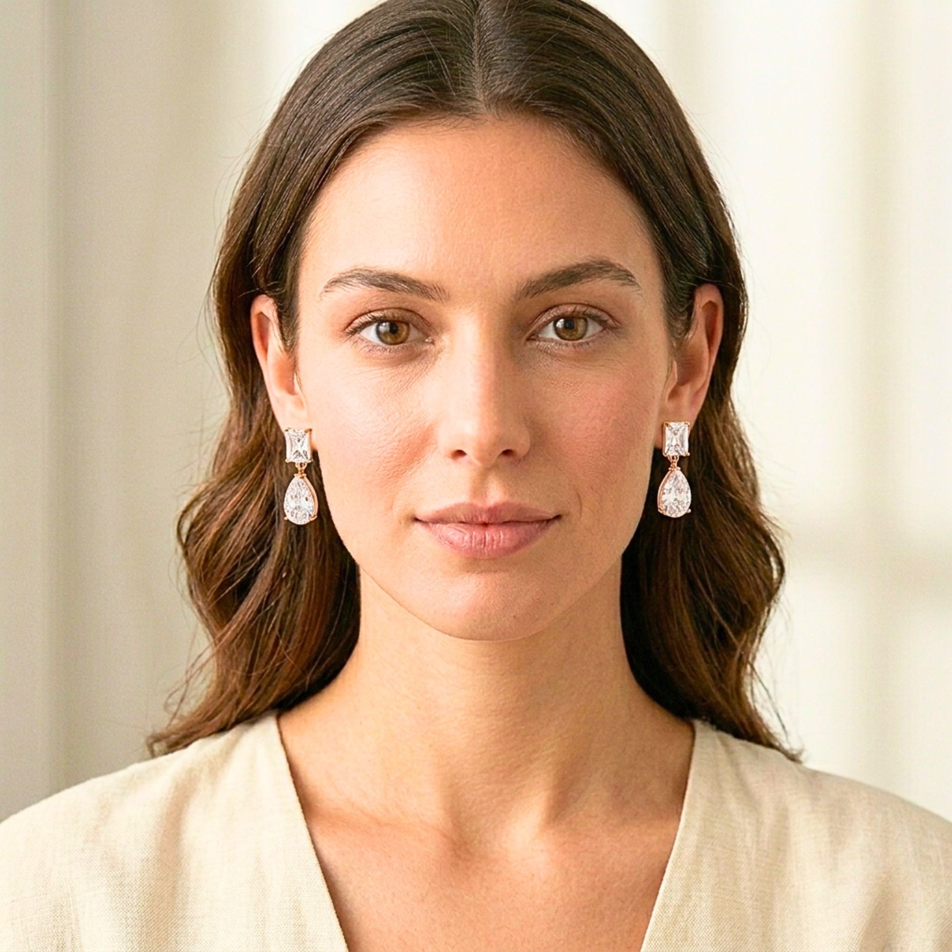 Woman wearing diamond earrings with a neutral background.  Digitally rendered person wearing authentic jewellery.