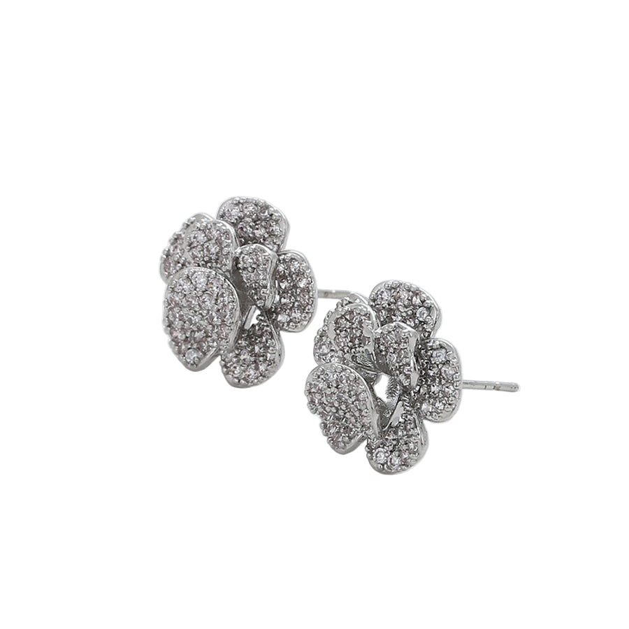 Pair of white gold floral earrings on a light background