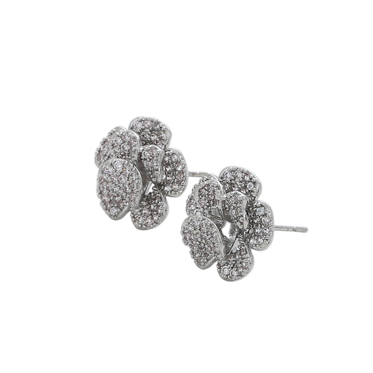 Pair of white gold floral earrings on a light background