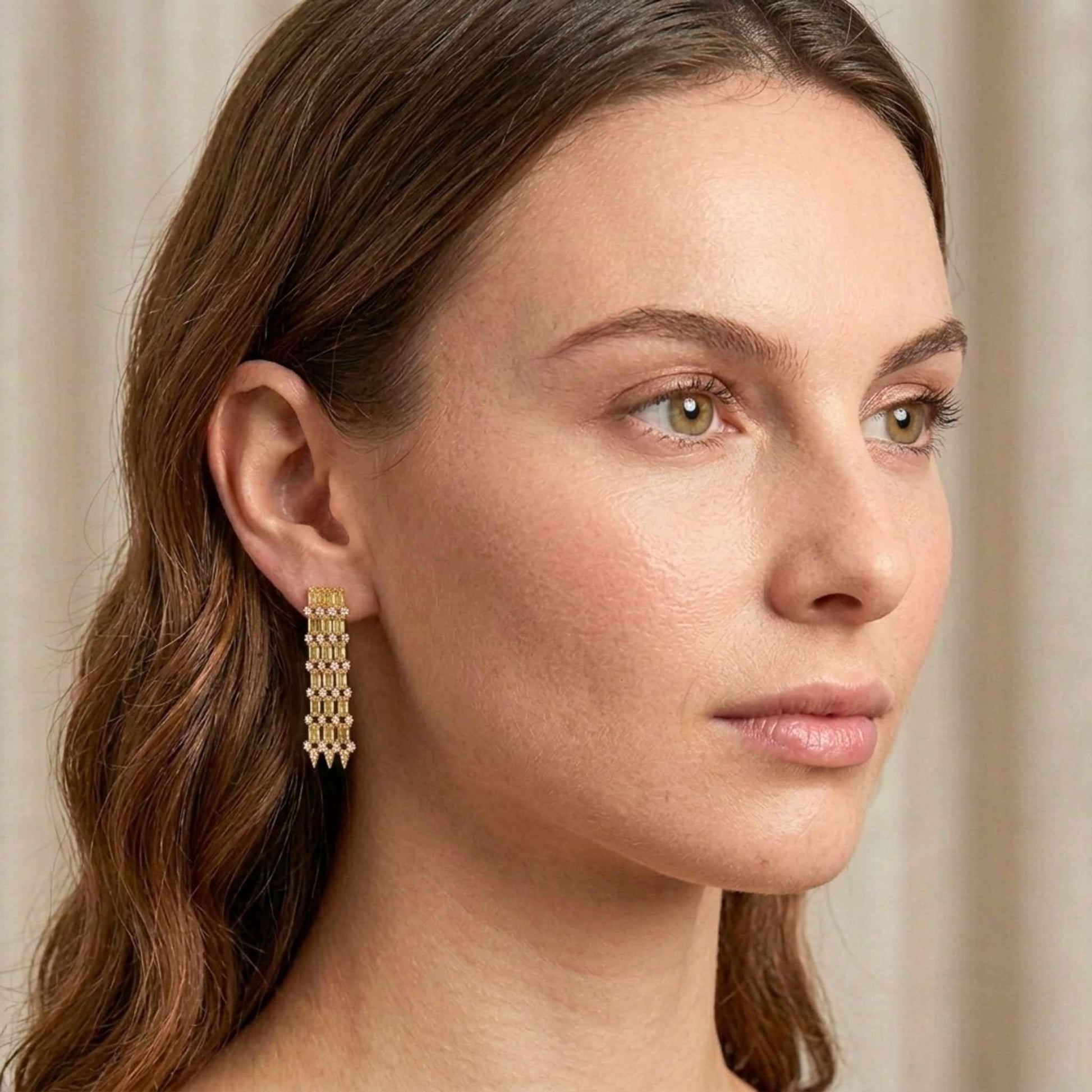 Woman wearing gold earrings with a neutral background.  Digitally rendered model for scale.