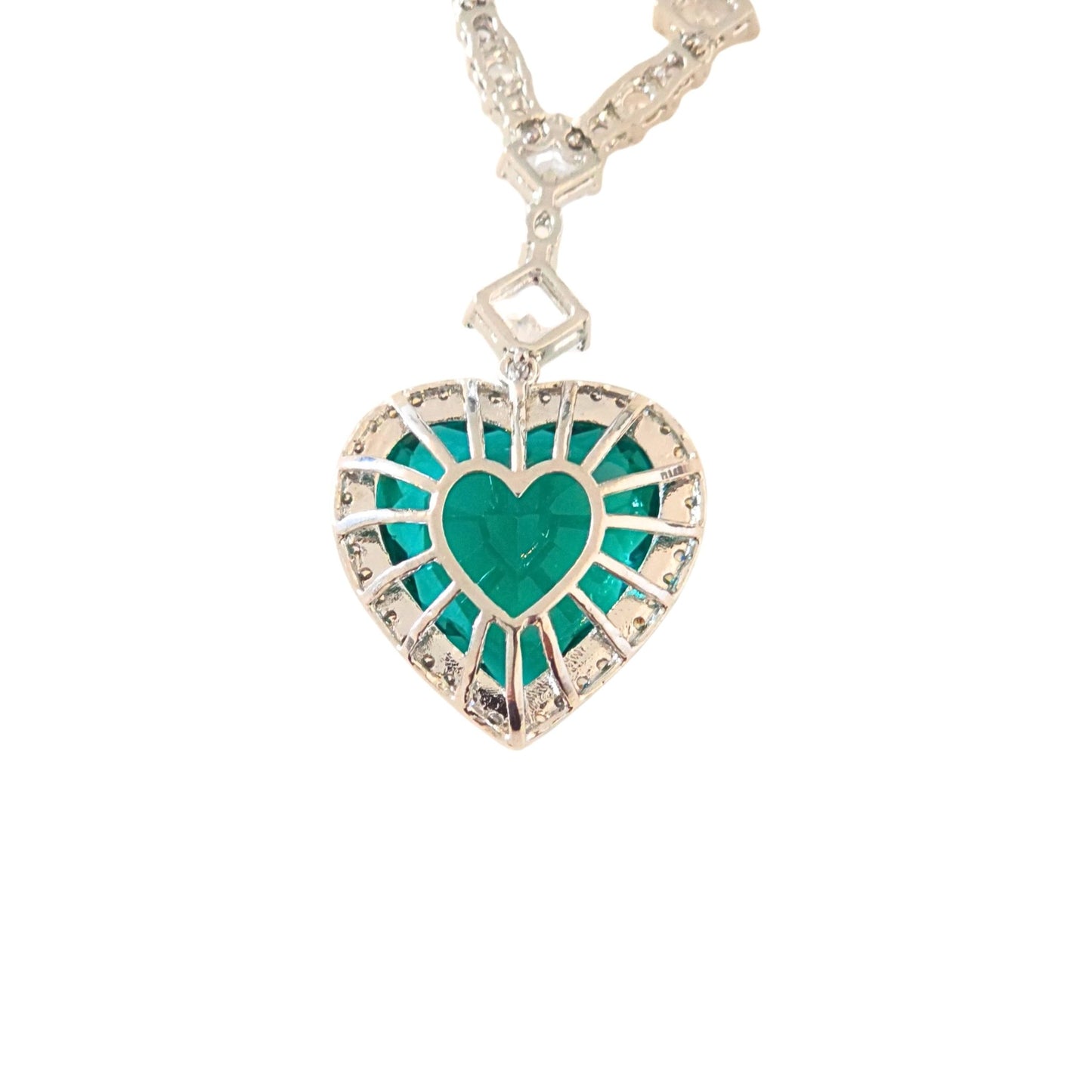 The back of a heart-shaped pendant with green centre and white gold border from the Jewellery 4 Elegance necklace and earring set colletcion on a white background